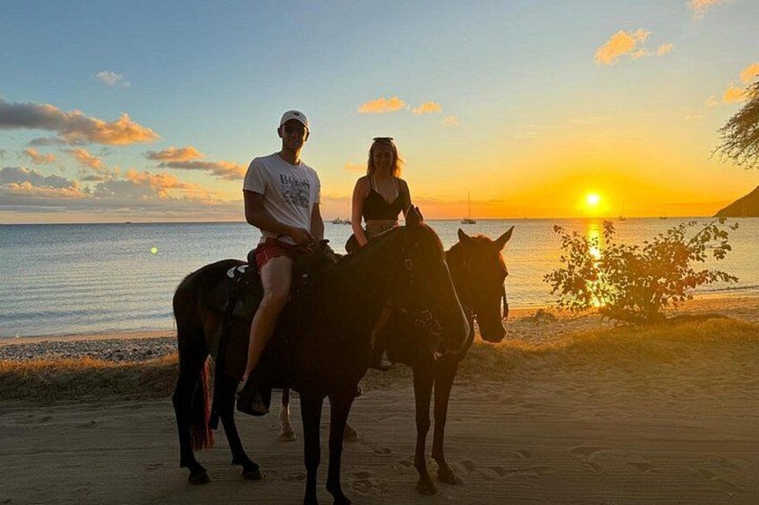 Dos personas montando a caballo en una playa al atardecer. 3