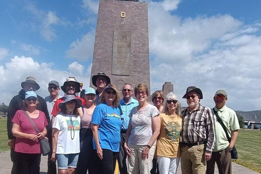 A group of people standing in front of a tall, rectangular monument with inscriptions. 4