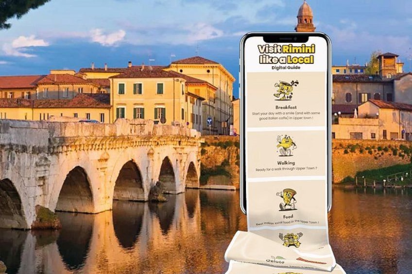 A smartphone with a digital guide for visiting Rimini, featuring a bridge, buildings, and a river. 1