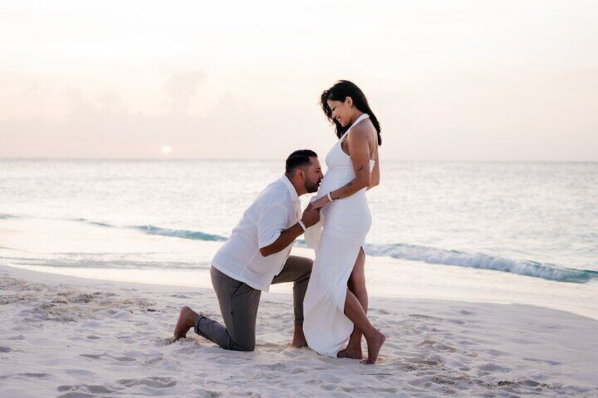 Een stel op het strand, de man knielt en doet een aanzoek aan de vrouw. 1