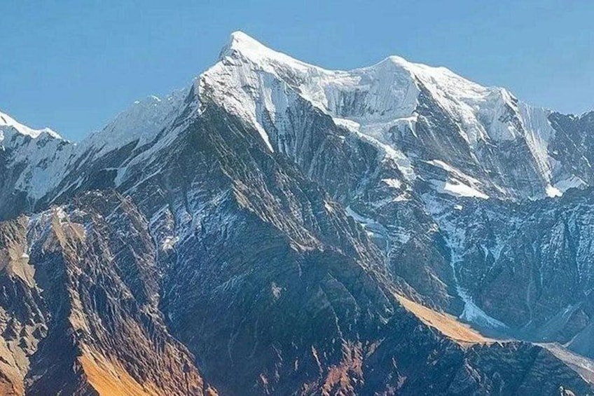 A snow-covered mountain range with rugged terrain and clear skies. 5