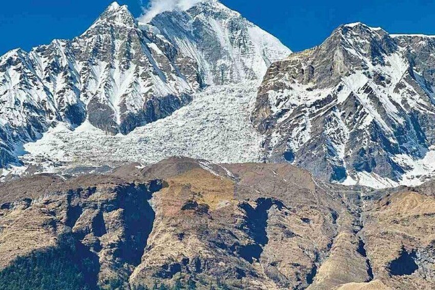 A snow-covered mountain range with sharp peaks and rugged terrain. 2