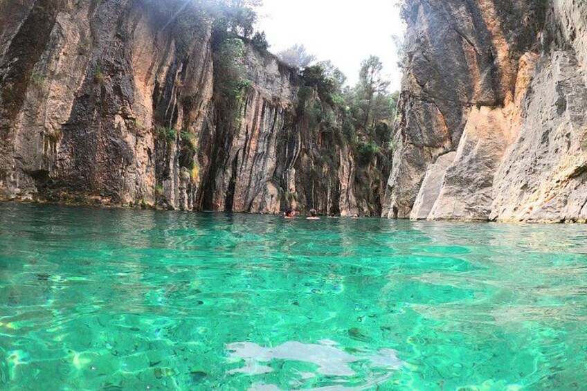 A clear turquoise sea with rocky cliffs. 1
