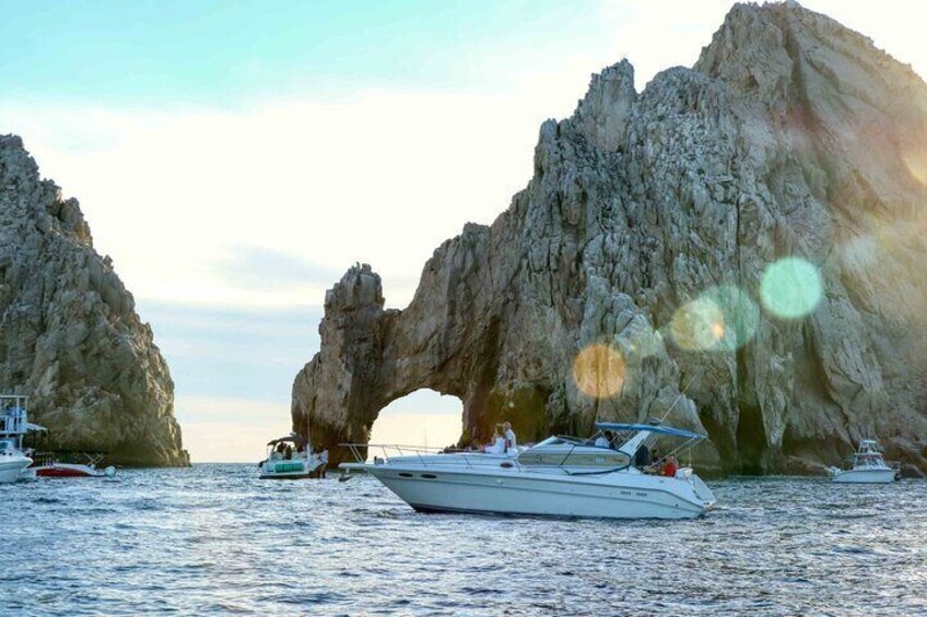 Un yate fondeado cerca de una formación rocosa natural en forma de arco en el mar. 1