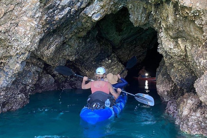 A person kayaking through a rocky cave. 1