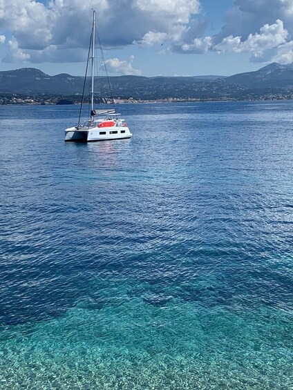 Een zeilboot op een heldere blauwe zee met bergen op de achtergrond. 5