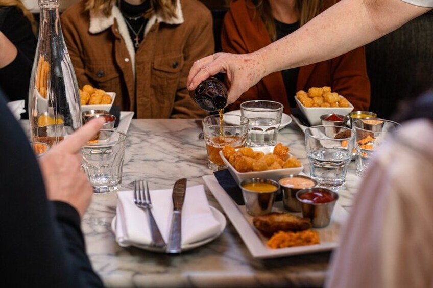 A dining table with food, drinks, and condiments. 1