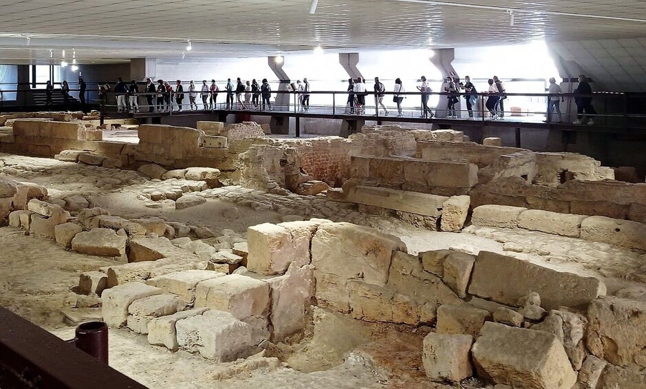 An archaeological site with stone ruins and a viewing platform. 3