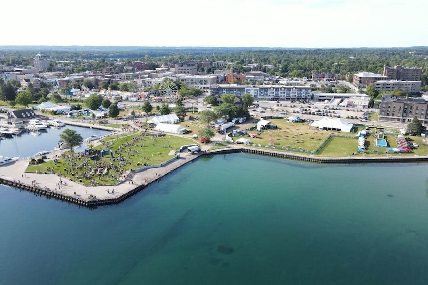 A marina with boats docked, a grassy area with people, and buildings in the background. 5