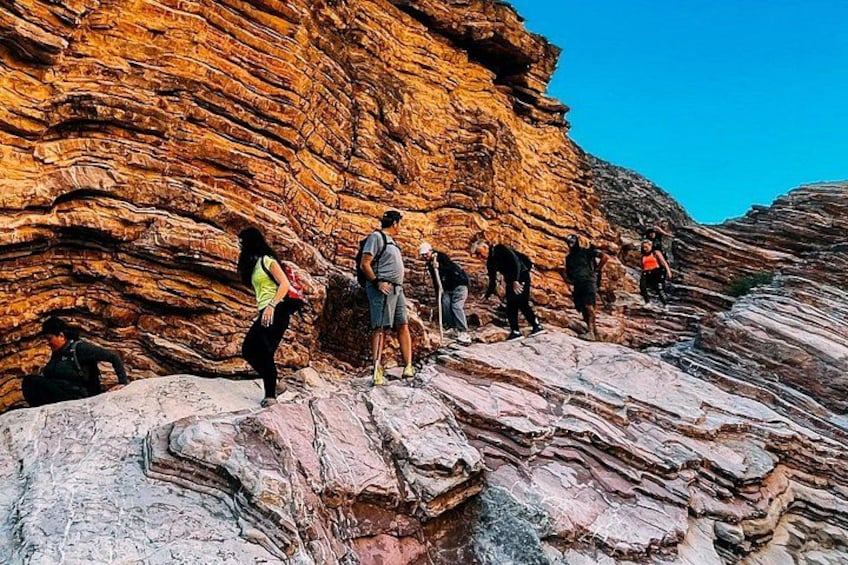 Un groupe de personnes fait de la randonnée sur un terrain rocheux, parsemé de formations rocheuses en strates. 2