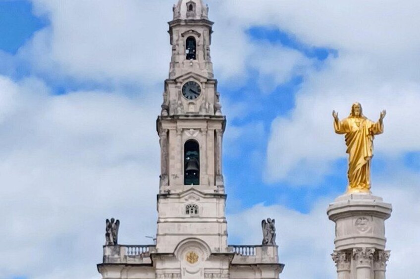 A clock tower with a golden statue on top. 1