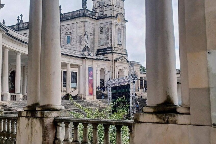 A historical building with columns, a clock tower, and a gated entrance. 2