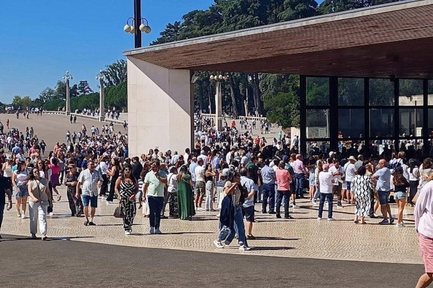 A crowded public square with a modern building and a large open area. 3