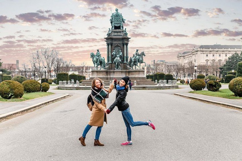 A statue in a park with two people posing in front of it. 4