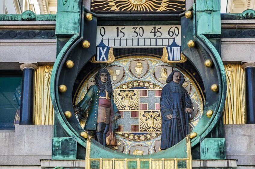A clock with Roman numerals and two statues. 3