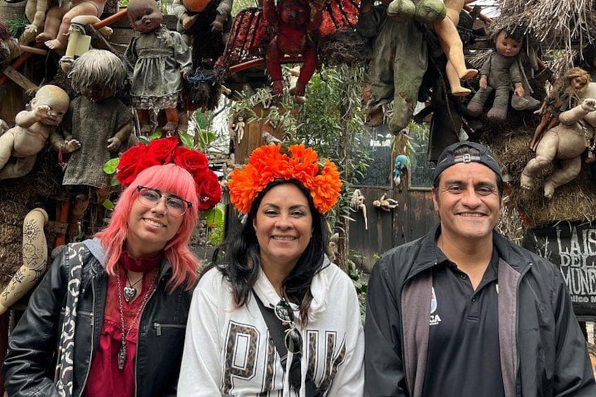 Three people in front of a wall of various objects. 3