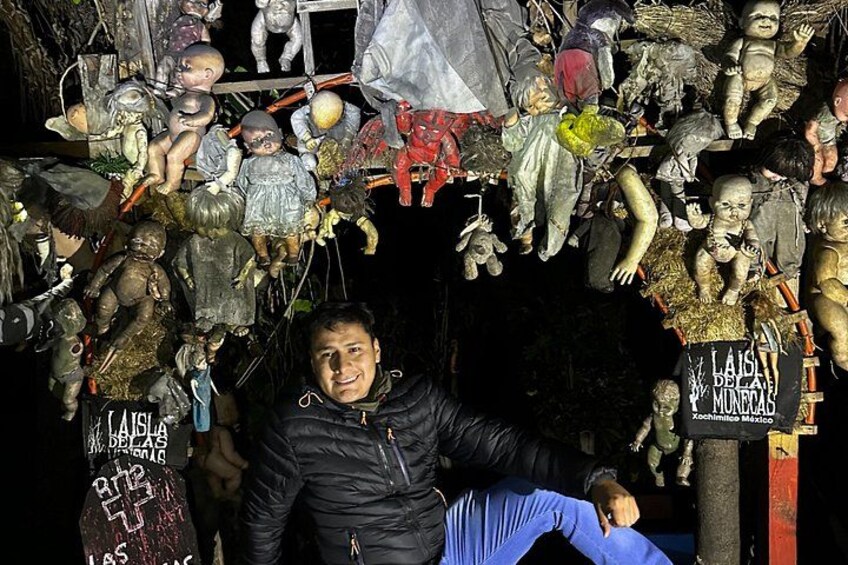 A person sitting in front of a display of dolls and figures. 5