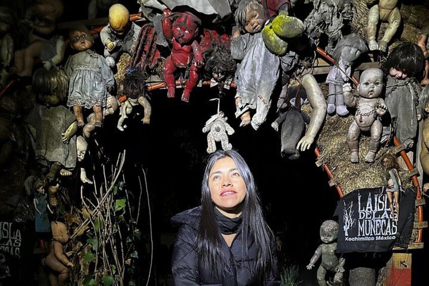 A collection of dolls and figures, some with hats, in a dark setting. 5