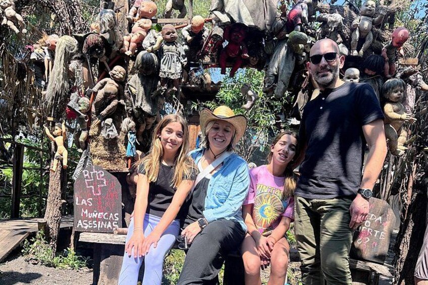 A group of people posing in front of a collection of dolls and figures. 2