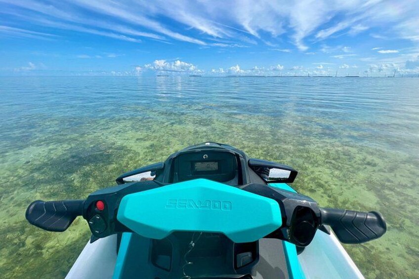 A jet ski on clear water with a distant shoreline. 4