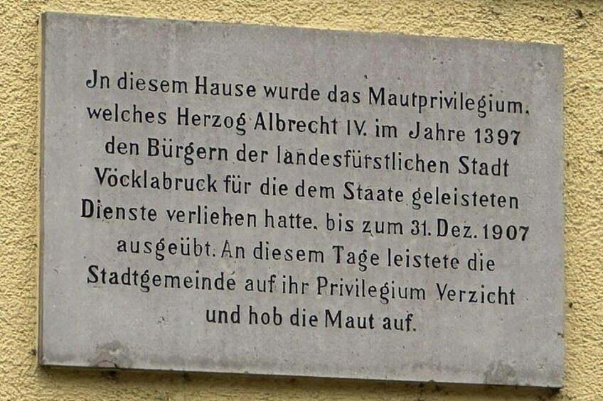 A plaque with historical text in German, mounted on a wall. 2