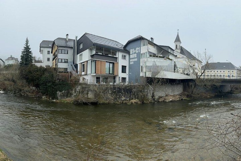 A river with buildings along its banks, including a cafe named 'B1+1'. 1