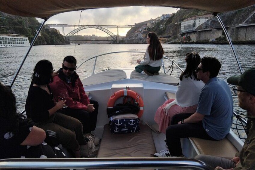Un grupo de personas en un barco, con un puente al fondo. 4