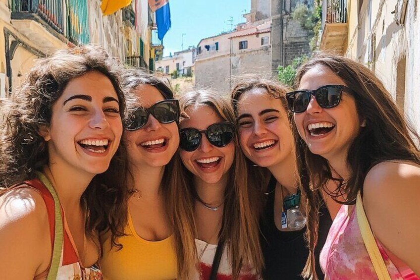 A group of people taking a selfie in a narrow street with buildings on either side. 3