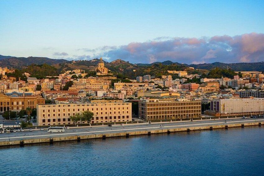 A coastal cityscape with a prominent building and a bridge over water. 5