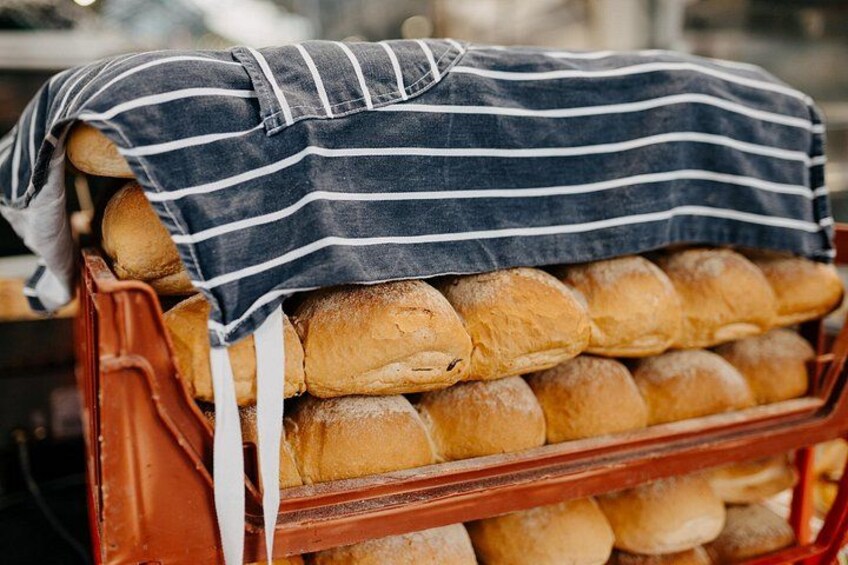 Una rastrelliera con pane appena sfornato, coperta da un telo a righe. 5