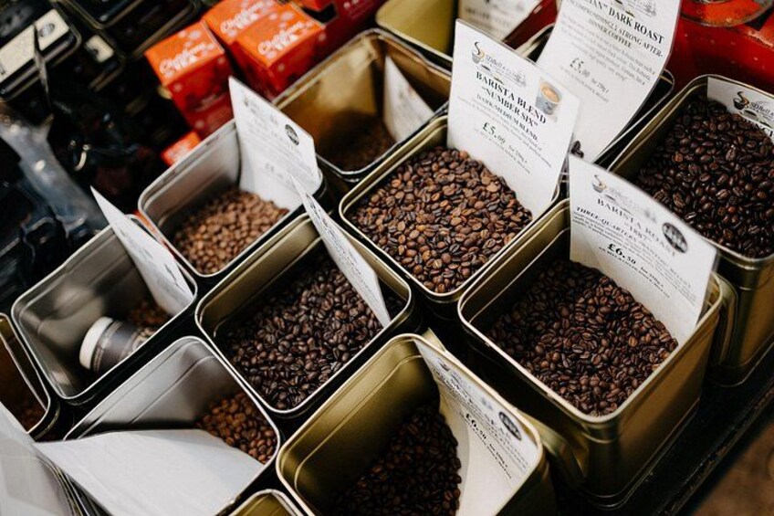 Diverse varietà di caffè in contenitori metallici con etichette. 4