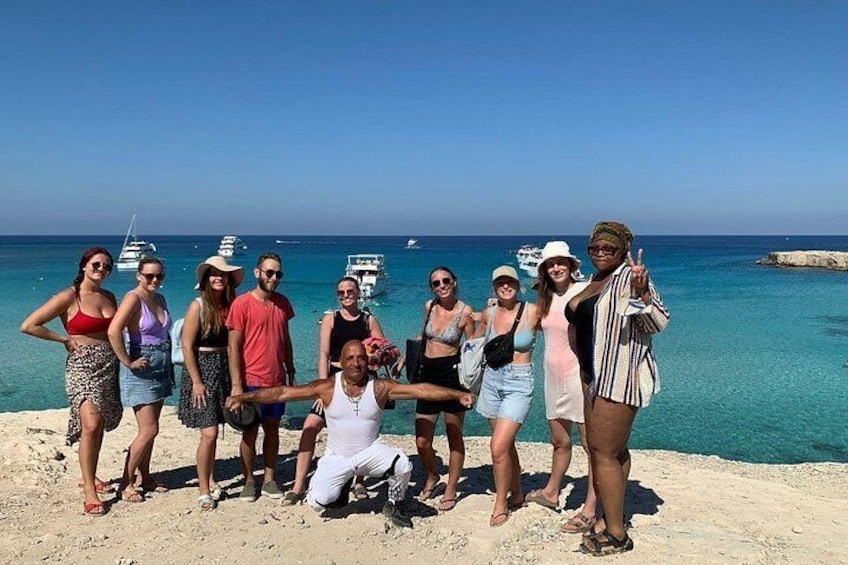 A group of people on a beach with boats in the background. 2