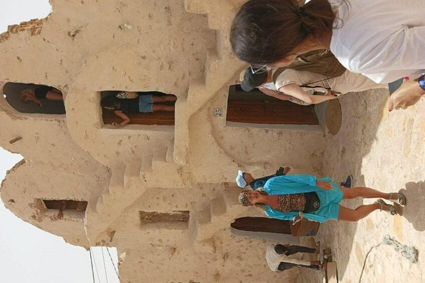 A large, ancient structure with multiple doorways and a central stone slab. 2