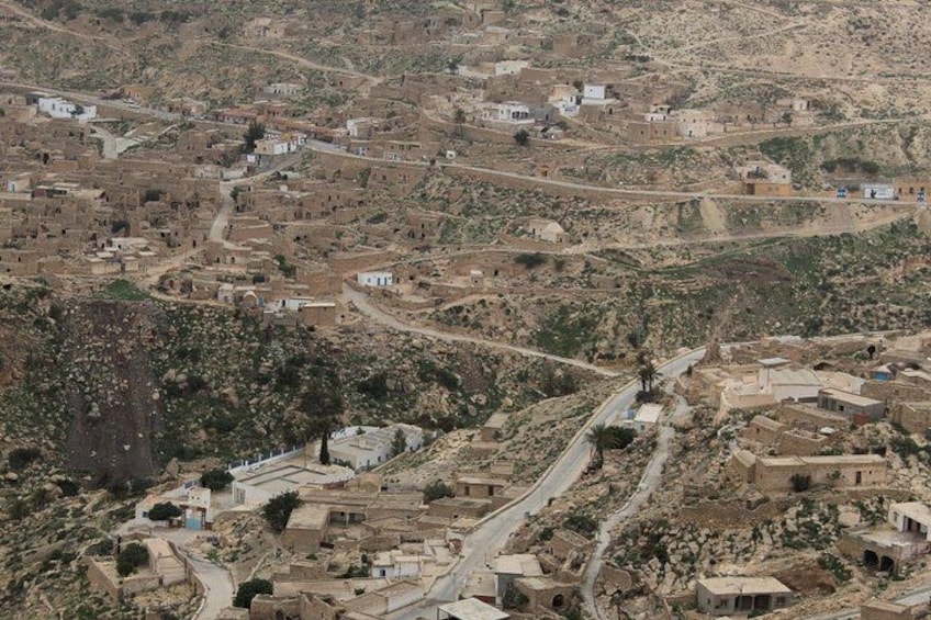 A hilly village with winding roads and scattered buildings. 3