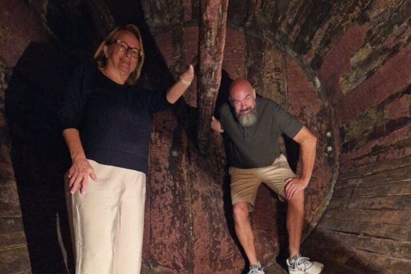 Dos personas de pie en un túnel de paredes de piedra. 2