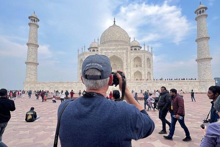En person tager et billede af Taj Mahal med Agra Fort i baggrunden. 1