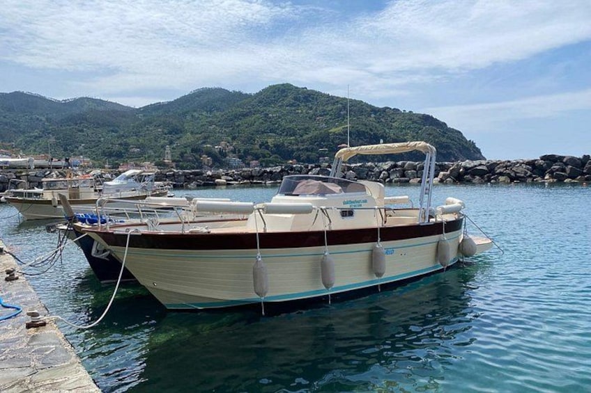 A boat docked at a harbor with mountains in the background. 2