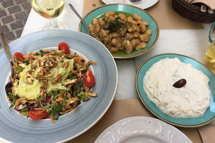 A table with various dishes including a salad, beans, and a creamy dip. 4