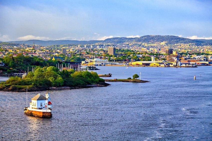 A harbor with a lighthouse, a small island, and a cityscape in the background. 4
