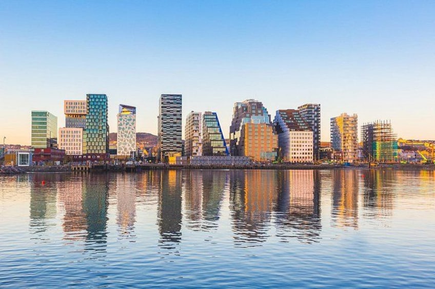 A city skyline with modern buildings reflected in calm water. 1