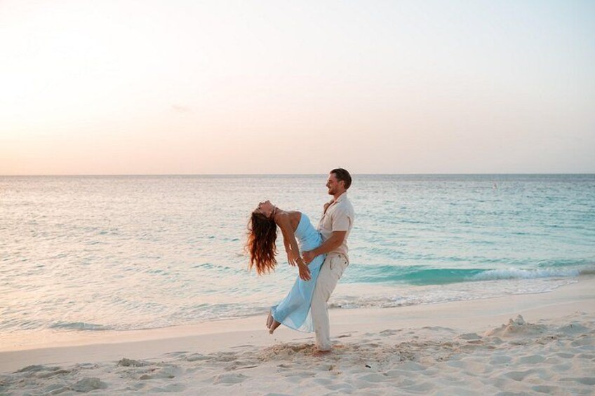 A couple on a beach with the ocean in the background. 2