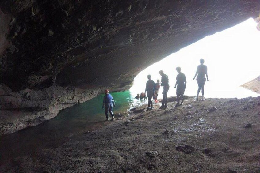 Un grupo de personas dentro de una cueva con una poza de agua. 4