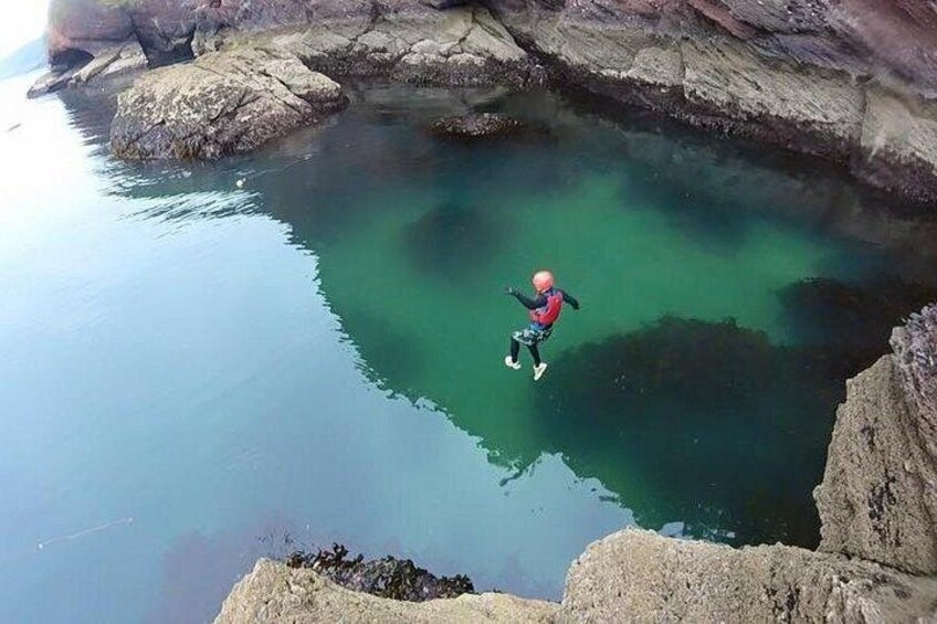 Una persona haciendo bungee jumping desde un risco hacia el agua. 5