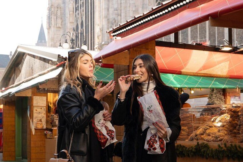 Two people eating at a food stall with a historic building in the background. 4