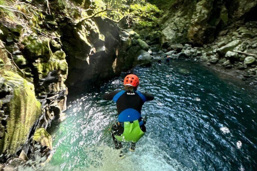 A person kayaking through a narrow, rocky river surrounded by cliffs. 4