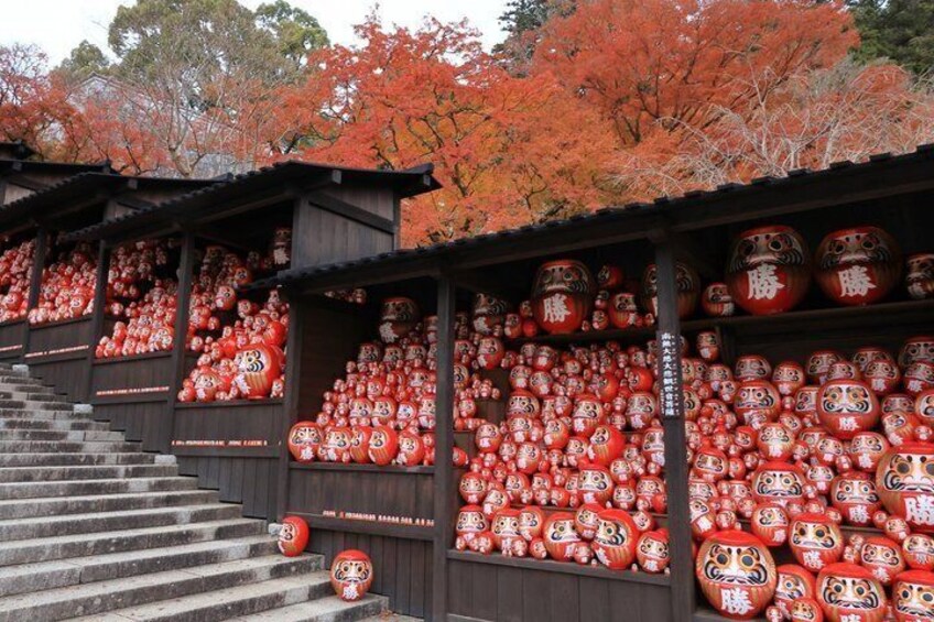 A staircase leading to a building filled with red and white Japanese dolls. 1