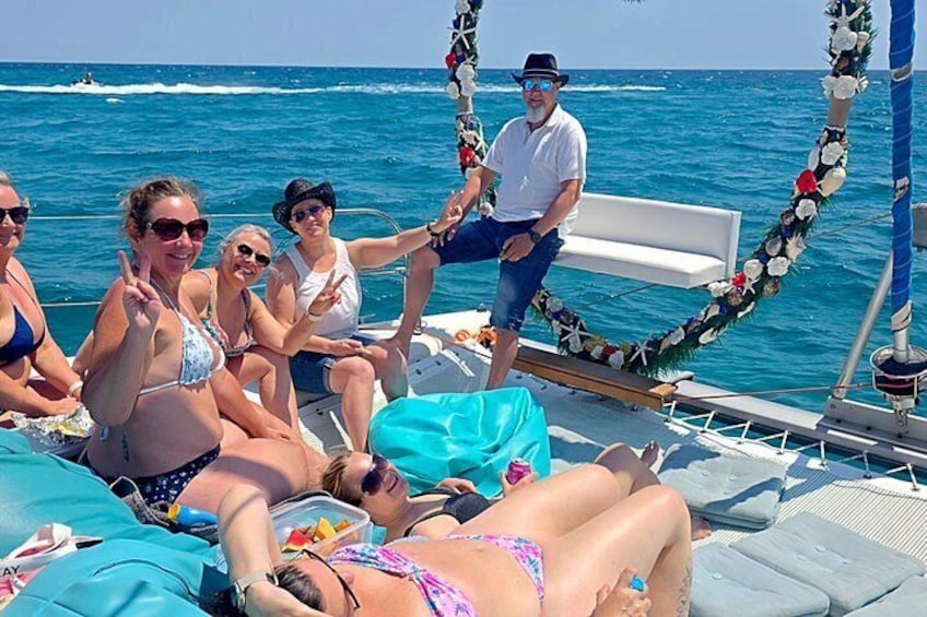 A group of people on a boat with a blue ocean and clear skies in the background. 4
