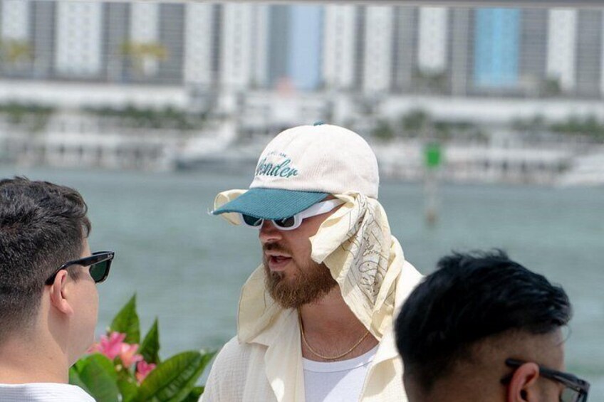 A person wearing a white cap and sunglasses, with a city skyline in the background. 4