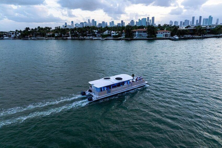 A riverboat with passengers, a city skyline in the background, and calm water. 5