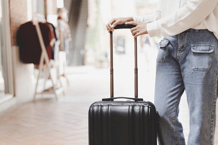 A person pulling a black suitcase with wheels. 2
